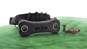cette photo montre le boitier Echo-blinddog pour grand chien en version réelle et en couleur. Echo-blinddog conçu pour aider les chiens aveugles sur un tapis à côté de l’Echo-blinddog, le petit boitier pour aider les chiens aveugles. Il conçu pour aider les chiens aveugles ou malvoyants à se déplacer et éviter les obstacles grâce à l’écholocalisation. Blindsight. Muffin's Halo, accessoires pour chiens aveugles